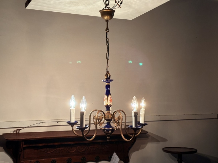 落ち着いた部屋で5灯の電球を優しく点灯させたシャンデリアの雰囲気（遠景）