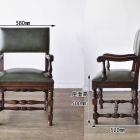 どっしりとしたオーク材の重厚感が魅力的な英国アンティークのアームチェア（c14）。力強い木目と安定感のあるフォルムが目を引く、肘掛け椅子の正面写真。