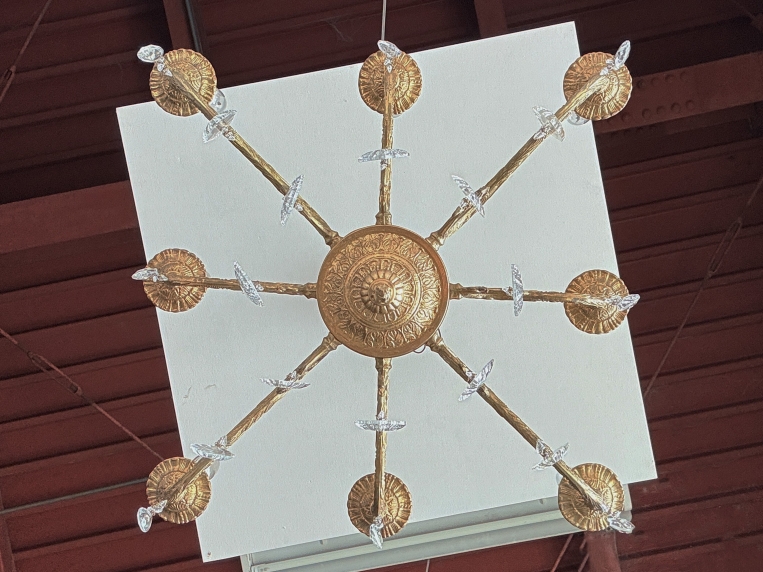 真鍮フレームを真下から見た構図。中心部から放射状に美しく伸びる8本のアームと細かな彫刻細工