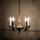 暗い室内で温かな光を放つ5灯シャンデリア。壁面に幻想的な影を映し出すキャンドルライトの演出。