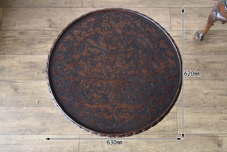 天板中央に深く彫り込まれた美しい花籠と、周囲を彩る花々のレリーフ。ヴィクトリアン様式特有の装飾美と、経年により深みを増した木肌の質感が、空間に圧倒的な存在感と風格をもたらします。