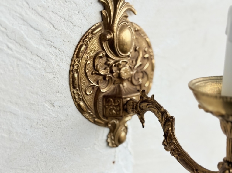 繊細な浮き彫り細工が施された、ブラケットライトの壁面取付部分のディテール