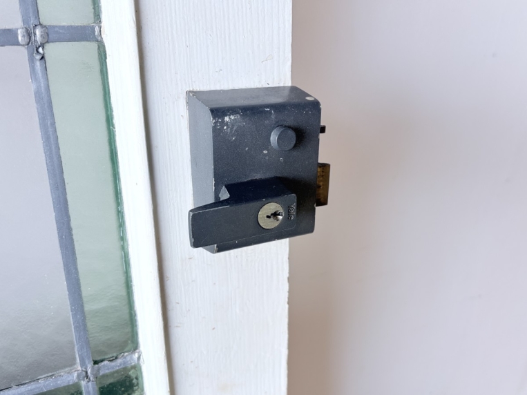 ドア裏面に取り付けられた黒い箱型の錠前金具