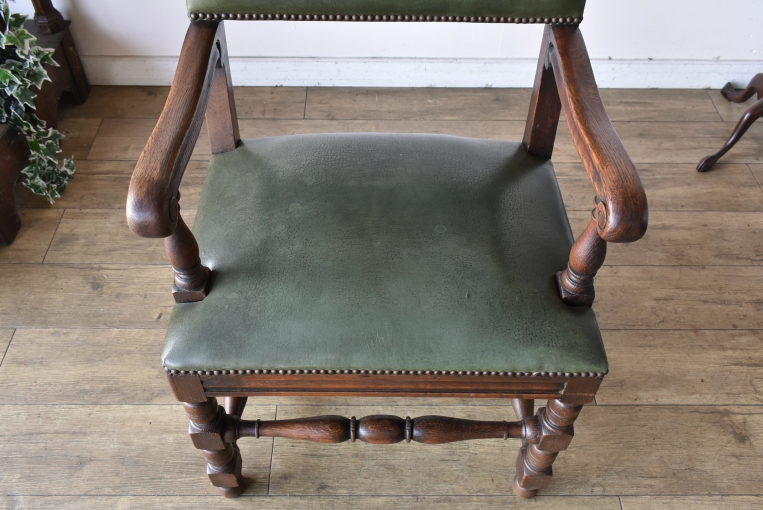 オーク無垢材を贅沢に使用した、滑らかな曲線を描くアーム部分。経年変化による深い色艶と、身体を優しく包み込むような堅牢な背もたれのディテール。