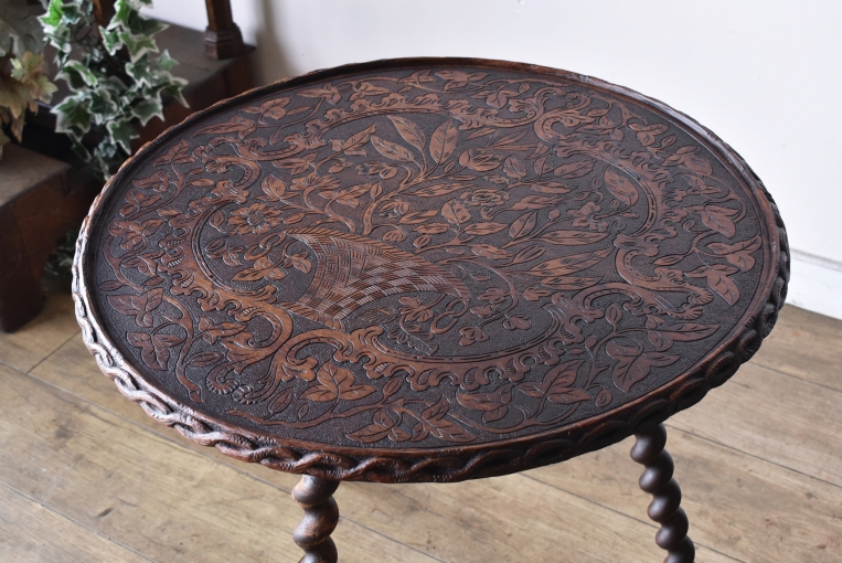 天板一面を覆う圧巻の彫刻細工。木材の贅沢な質感を活かし、蔓草や花々が優雅に絡み合う意匠は、置くだけで部屋の主役となるヴィンテージ家具ならではの贅沢な造りです。