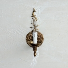 壁面に設置された、優雅なアームが特徴的な真鍮製ウォールランプの正面写真