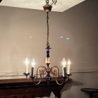 落ち着いた部屋で5灯の電球を優しく点灯させたシャンデリアの雰囲気（遠景）