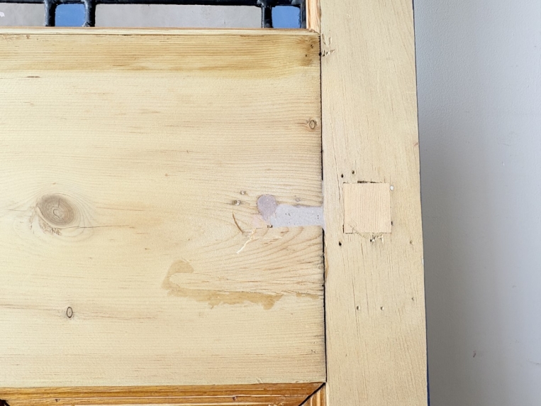 木肌側のステンドグラス下部と木製フレームの詳細。古い建具ならではの補修跡や使用跡が見られます。
